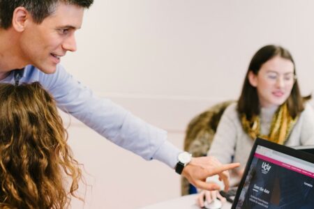 Enseignant et étudiante devant un ordinateur